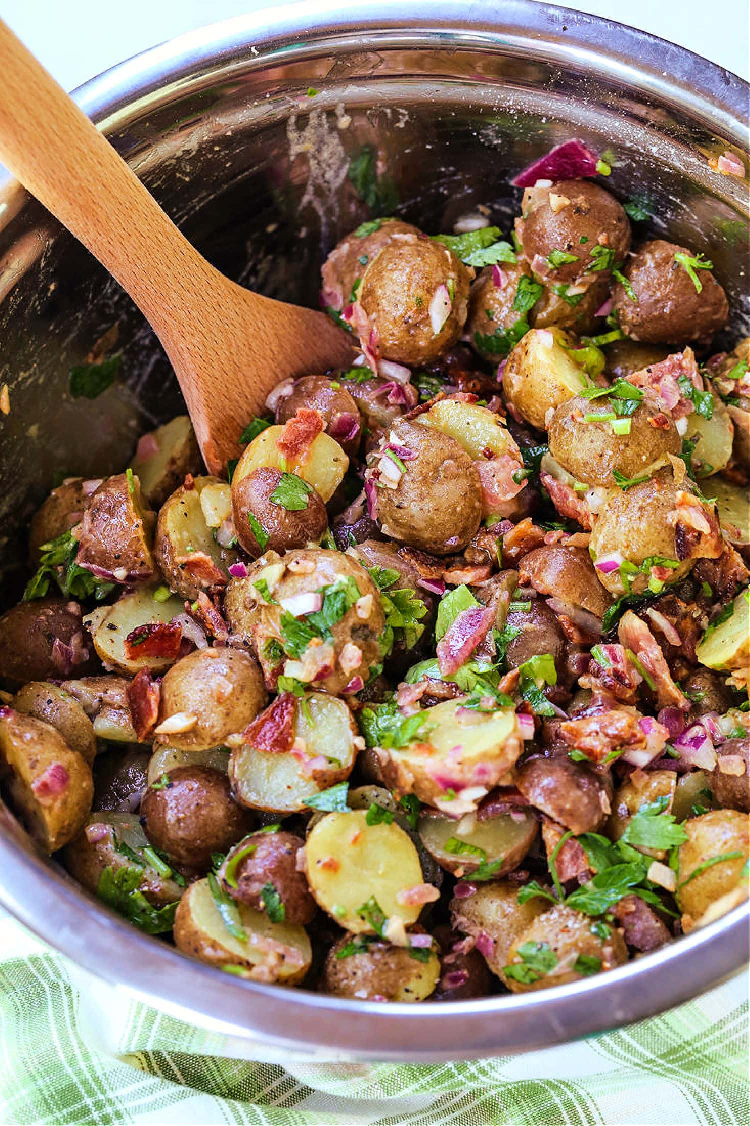 wooden spoon in bowl with potato salad