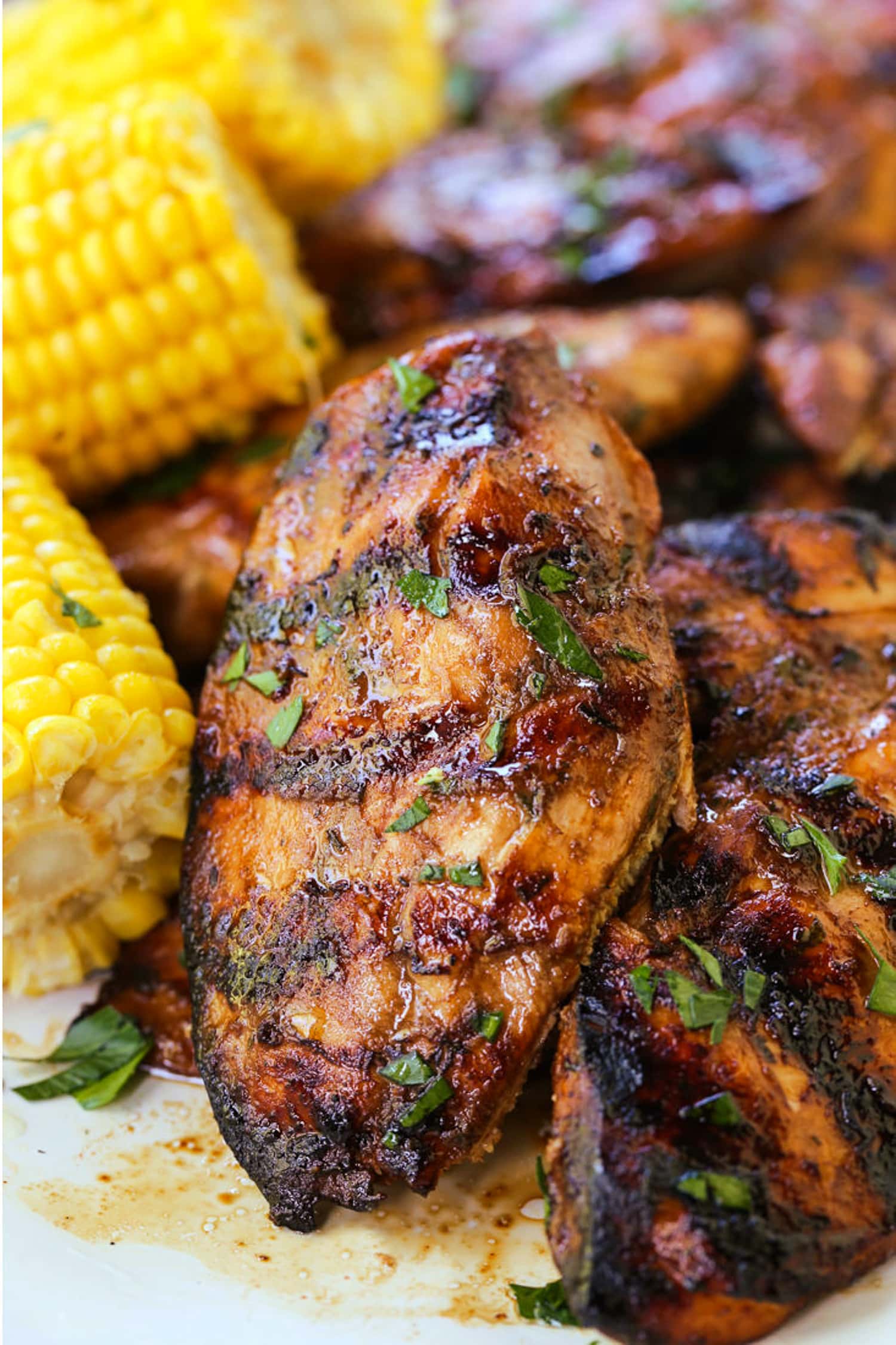 grilled balsamic chicken on a platter with corn on the cob