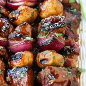 steak and vegetable kabobs stacked on platter