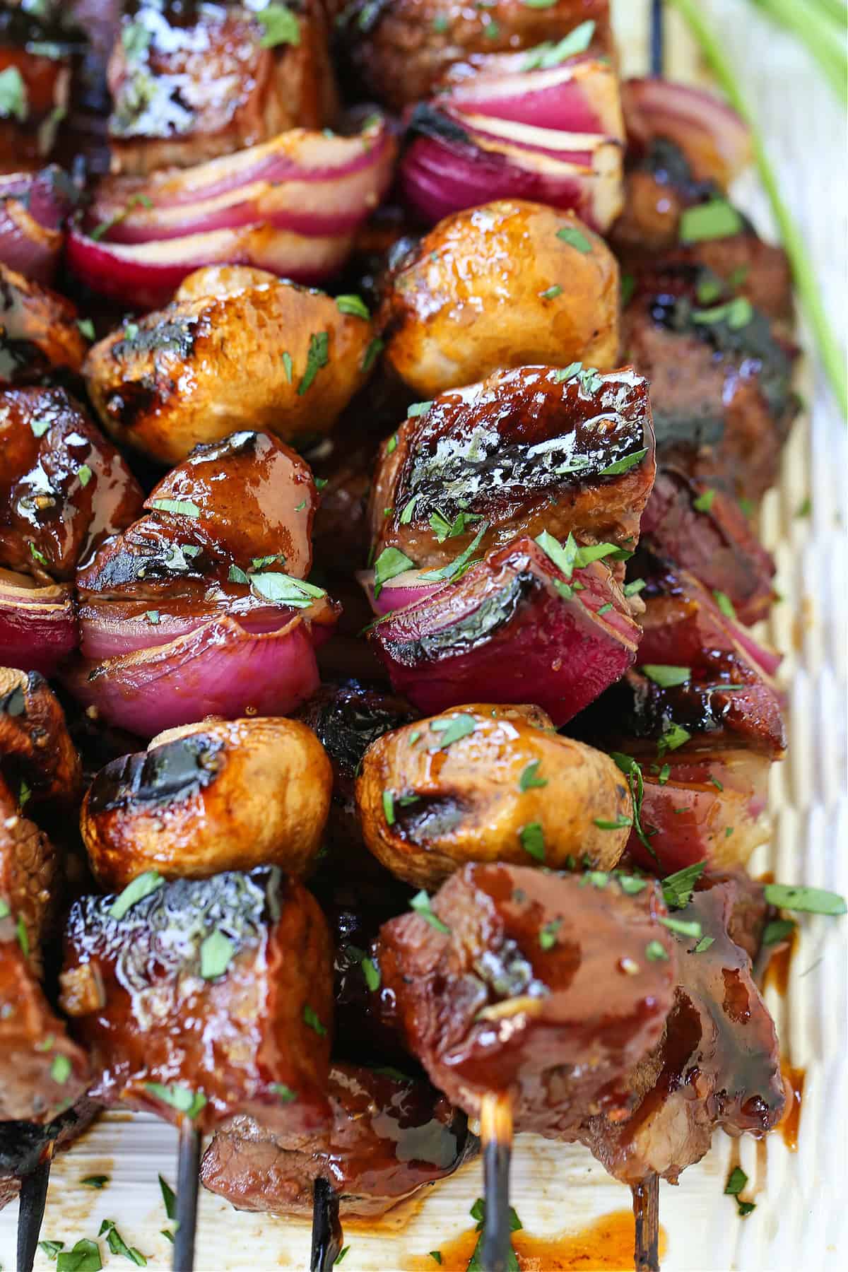 These Bourbon Steak Kabobs are always a hit! Grilled kabobs with tender steak and vegetables brushed with a brown sugar and bourbon glaze. steak and vegetable kabobs stacked on platter