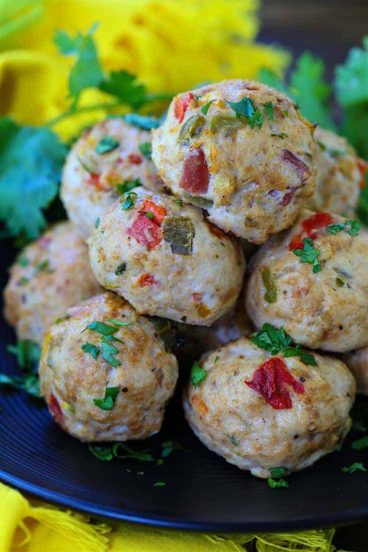 baked chicken fajita meatballs on a black plate