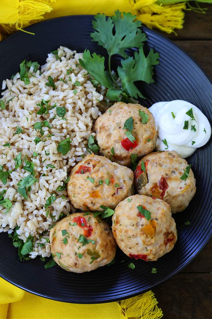 chicken meatballs on a plate with rice and sour cream