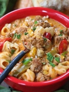 Soup recipe with sausage and pasta in a bowl with spoon