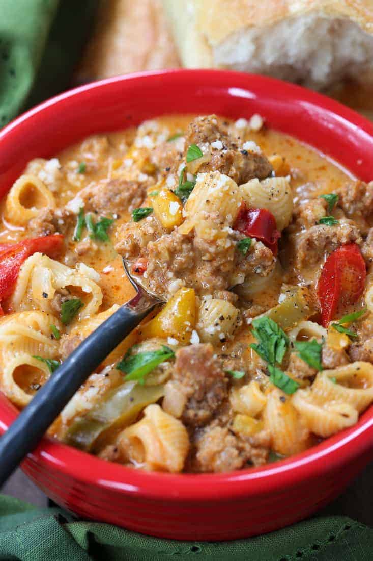 Soup recipe with sausage and pasta in a bowl with spoon