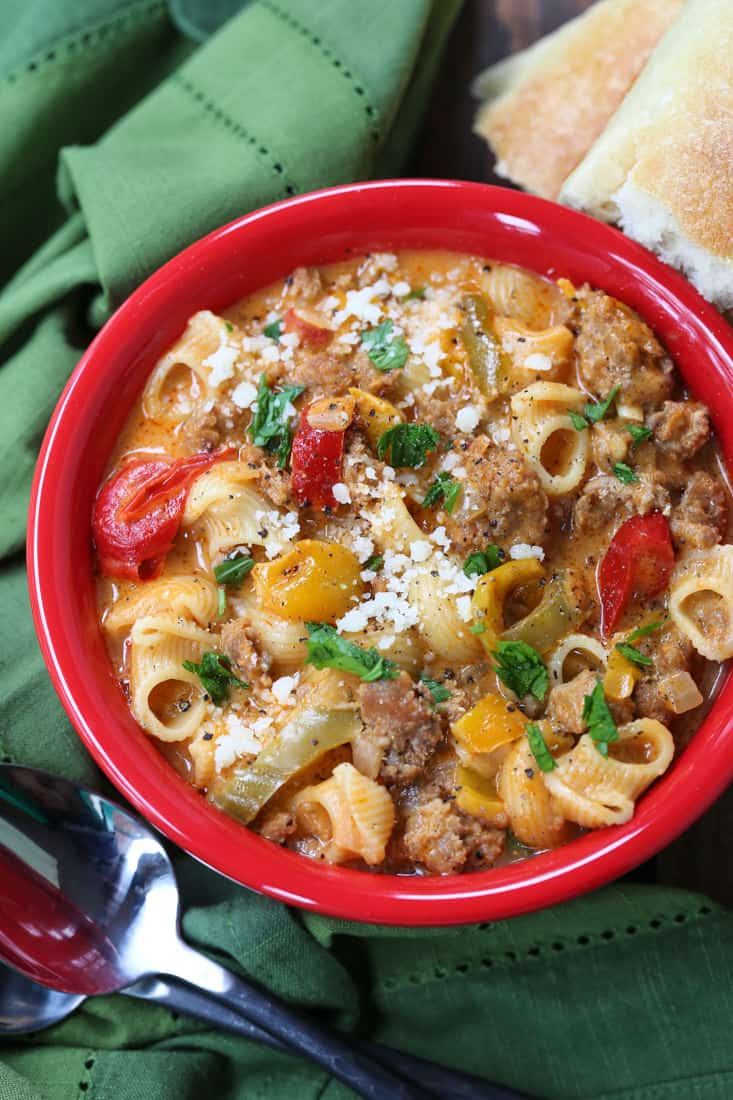 Sausage and Peppers soup in red bowl with green napkin