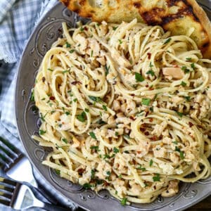 Linguine with clam sauce in a grey bowl with bread