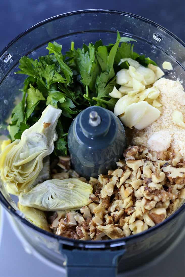 ingredients for an artichoke pesto in a food processor