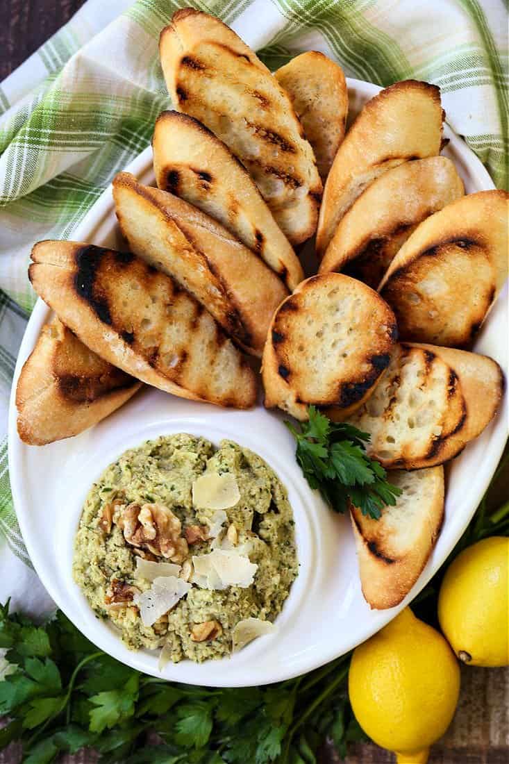 Artichoke Walnut Pesto on a platter with toasted crostini