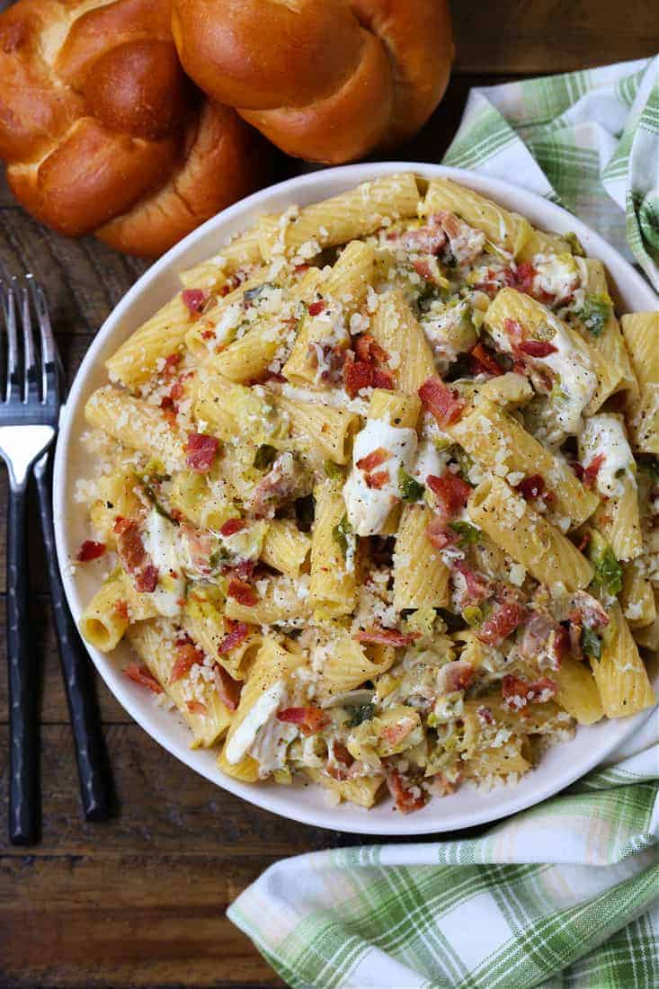 Rigatoni with bacon and brussels sprouts in a bowl with forks