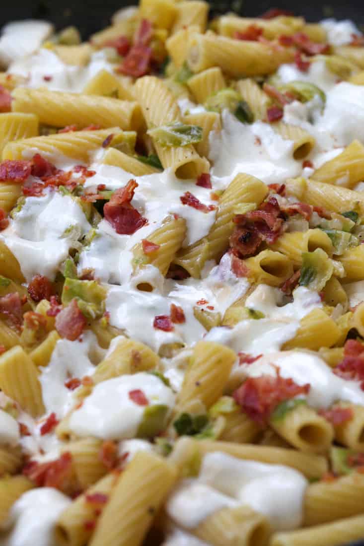 Rigatoni in a skillet with bacon and mozzarella cheese