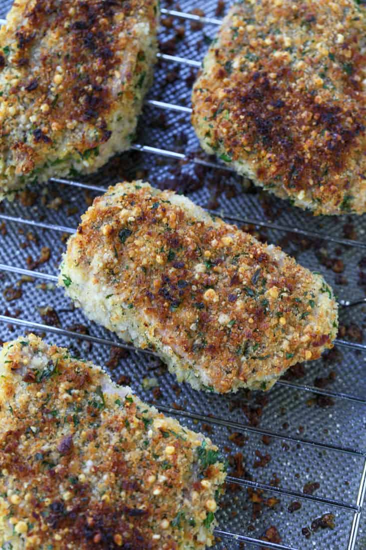 Oven baked pork chops on a rack over a baking sheet