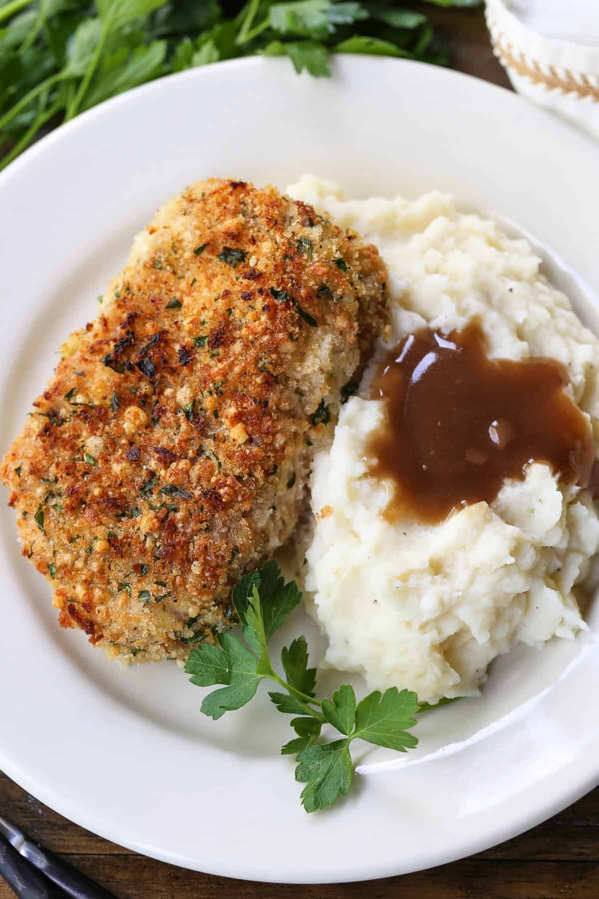Crispy Baked Pork Chops have a panko breadcrumb and parmesan cheese crust that's so addicting. Crispy on the outside with a juicy inside. baked pork chops with mashed potatoes on the side