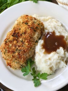 baked pork chop on a plate with mashed potatoes