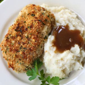 baked pork chop on a plate with mashed potatoes