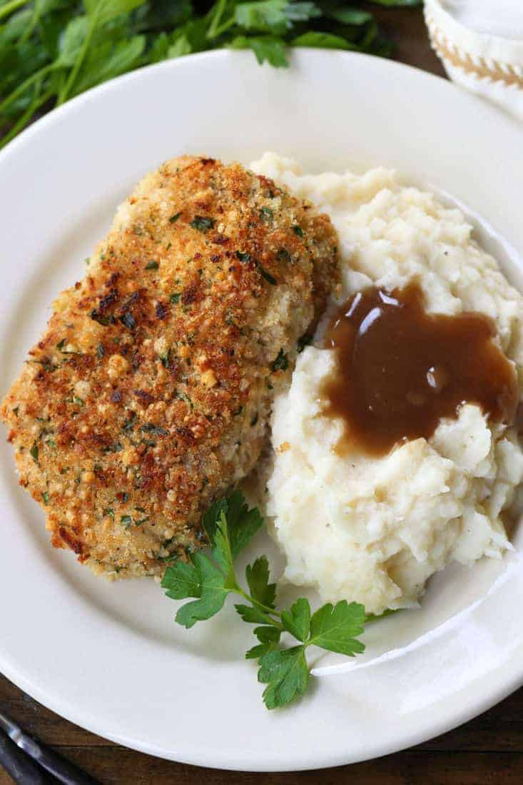 baked pork chop on a plate with mashed potatoes