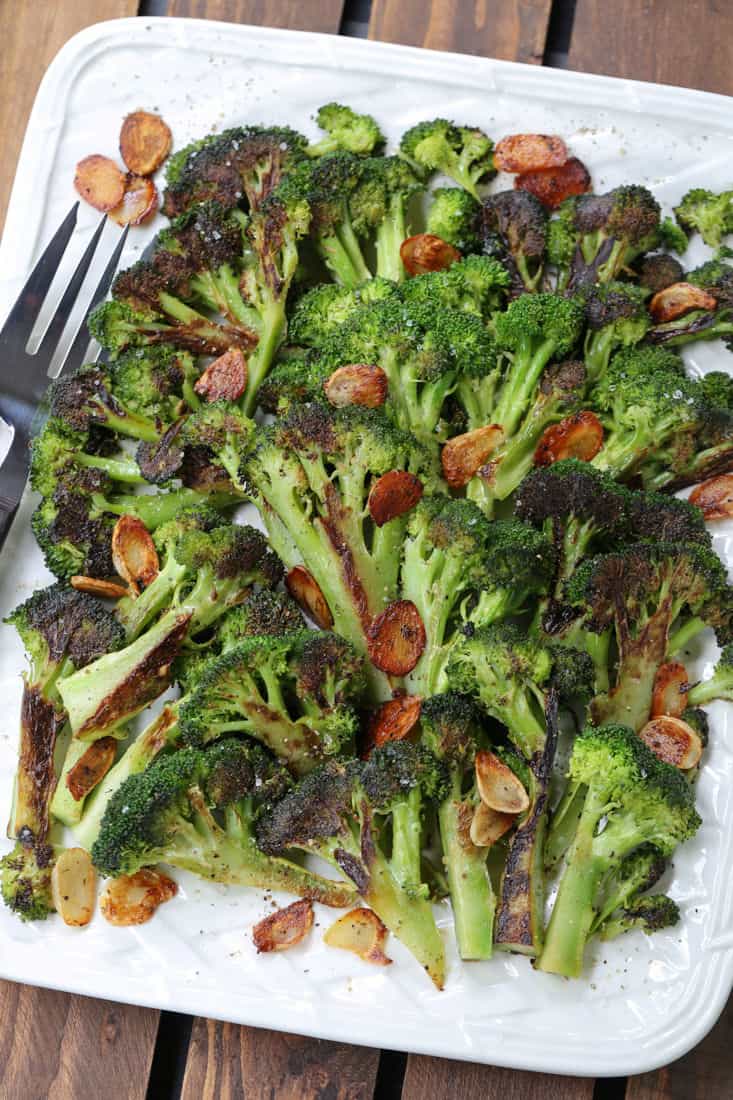 Garlic Roasted Broccoli on a platter with fork and spoon