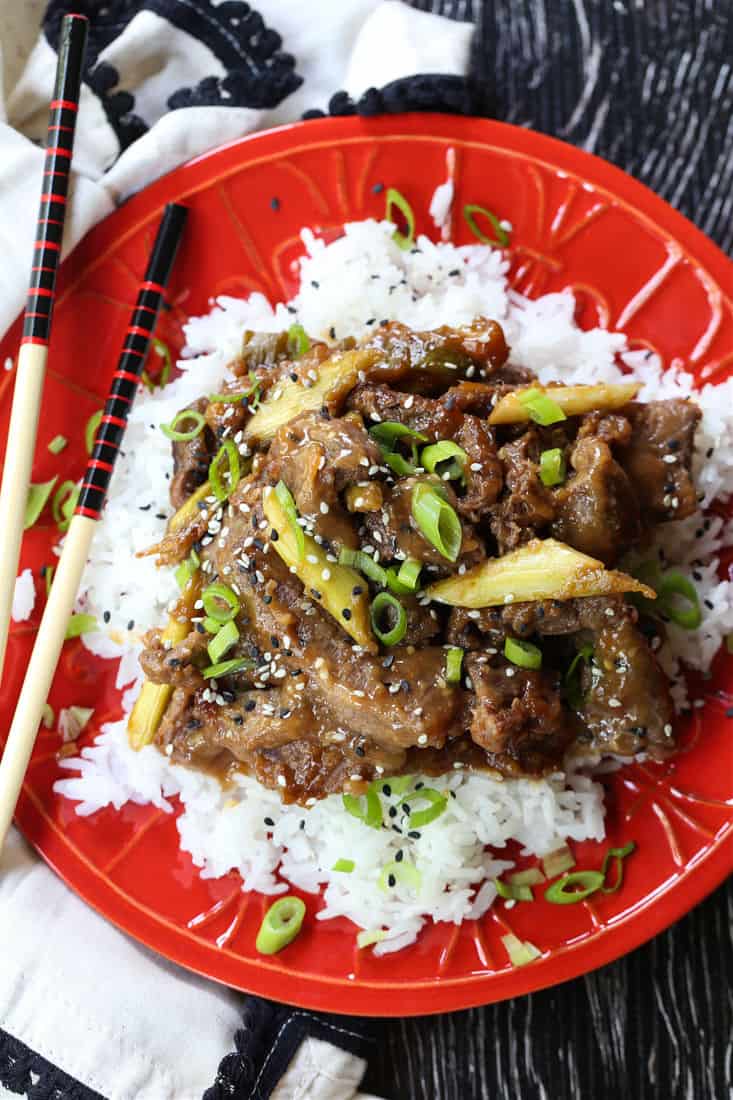 Slow Cooker Mongolian Beef on a red p ate with rice