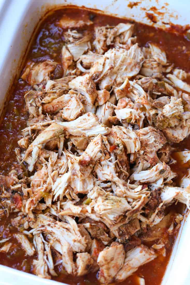 Pulled chicken in a slow cooker smothered in chipotle sauce.