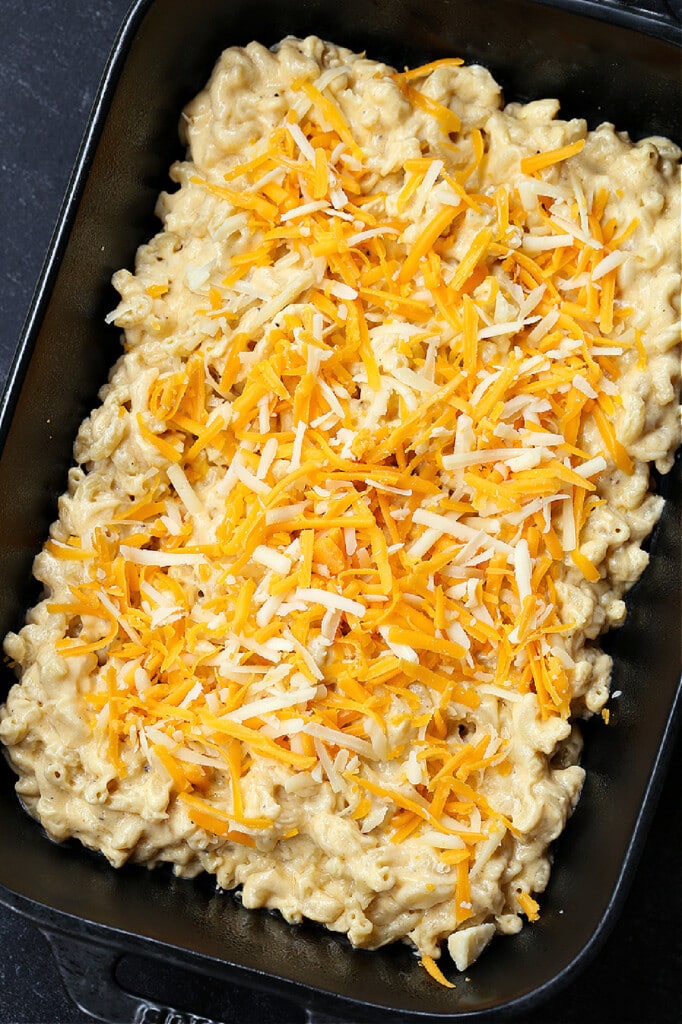 shredded cheese on top of a macaroni and cheese casserole