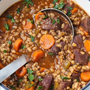 Beef Barely Soup in a pot with a ladle