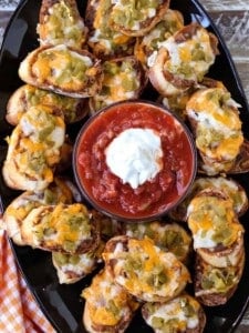 Mexican crostini on a platter with salsa and sour cream