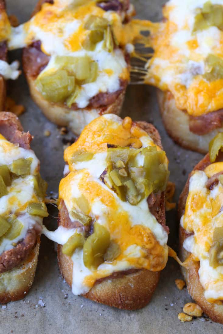 Baked crostini on a sheet pan with melted cheese