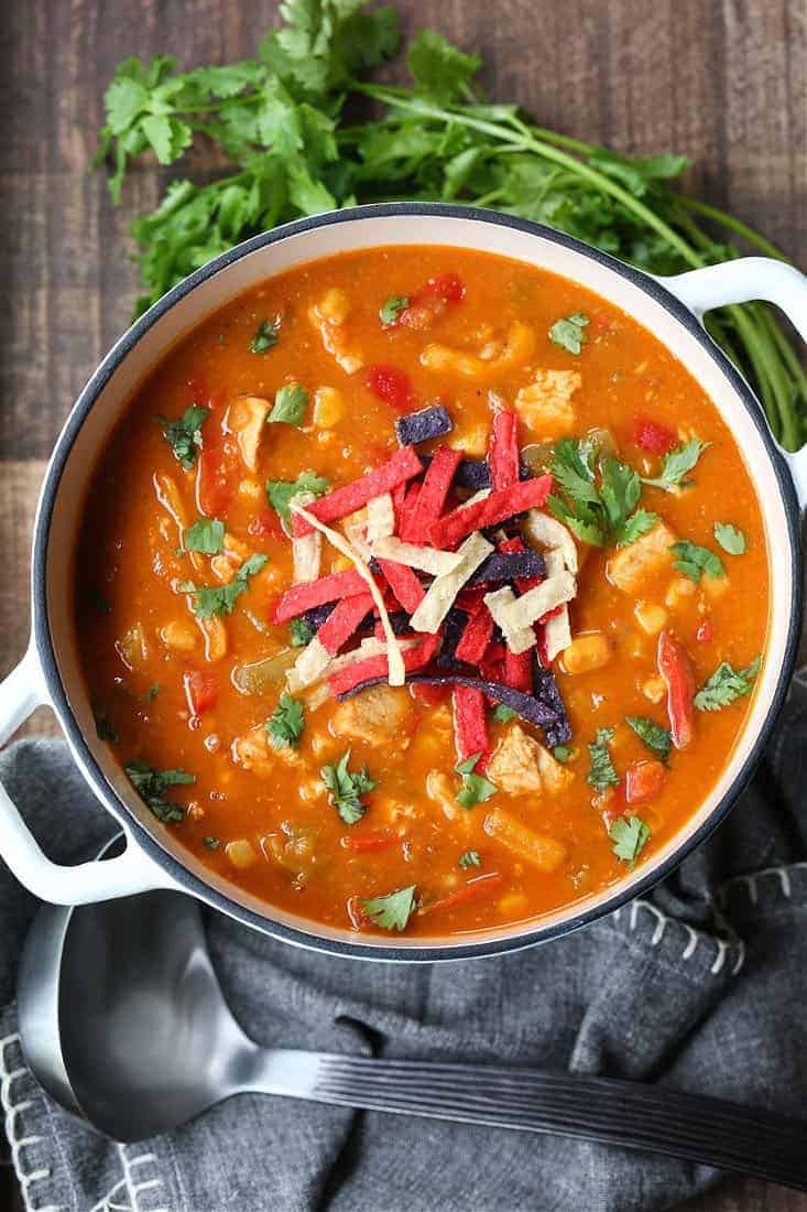 Creamy Chicken Fajita Soup in a pot with cilantro and tortilla strips