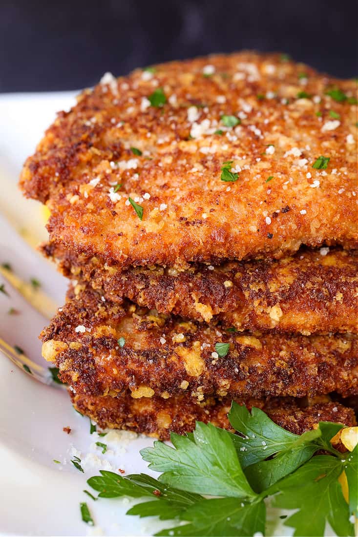 Crispy chicken cutlets stacked on a plate