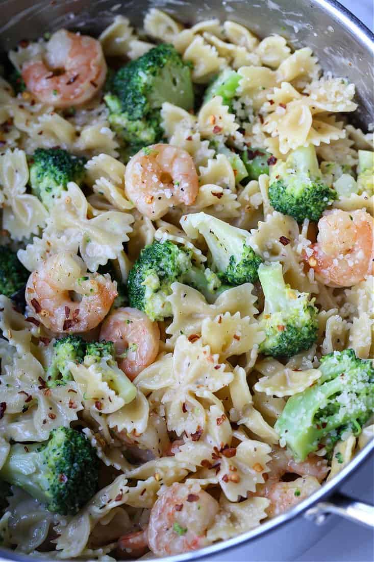 Shrimp and Broccoli Pasta has the most delicious, lemon cream sauce that coats every bit of pasta! A light pasta dinner that everyone loves! Bowties and broccoli in a pot with shrimp