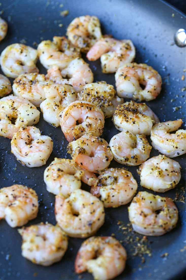 Shrimp and Broccoli Pasta has the most delicious, lemon cream sauce that coats every bit of pasta! A light pasta dinner that everyone loves! shrimp with lemon pepper seasoning in a skillet