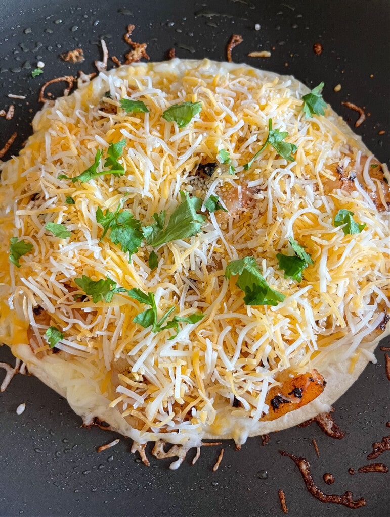 cheese and shrimp on tortilla for making quesadilla