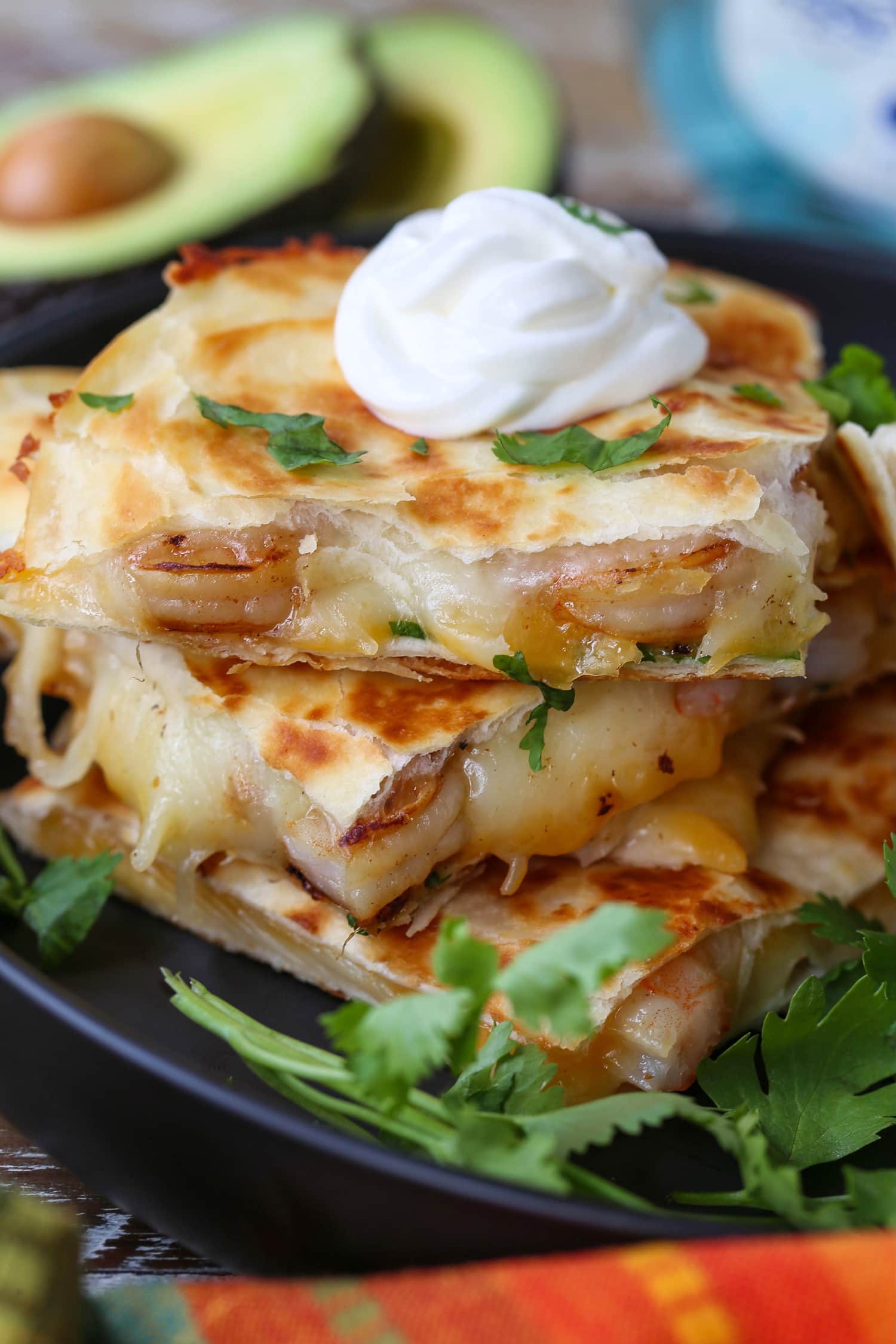 shrimp quesadillas stacked on a plate with sour cream