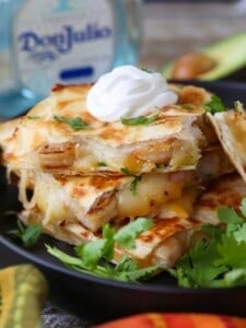 Tequila Shrimp Quesadillas stacked on a plate with tequila bottle