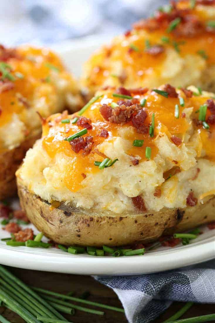 Twice Baked Potatoes are a delicious side dish that can be totally made ahead of time! Creamy, cheesy potato filling in a crispy baked skin! twice baked potatoes with bacon and cheese