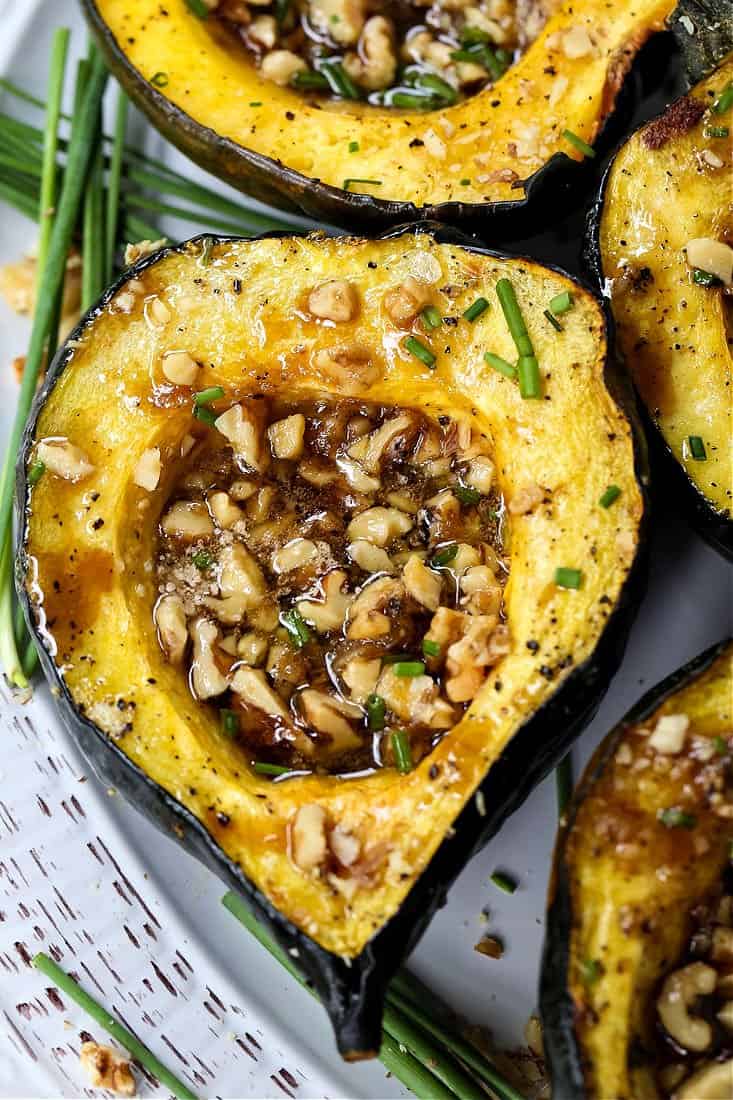 Roasted Acorn Squash cut in half and filled with nuts and brown sugar.