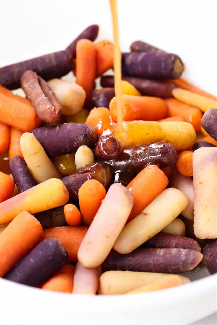 Honey glaze being poured over carrots