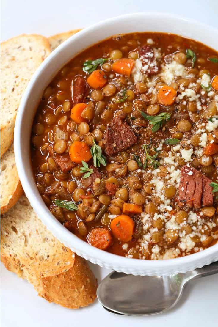 Lentil Soup with Ham in a white bowl with bread on the side