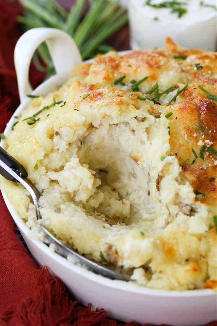 Potatoes Romanoff in a baking dish with spoon