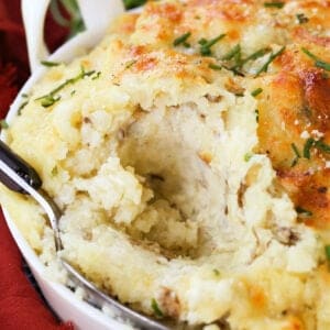 spoon in mashed potatoes with sour cream in background