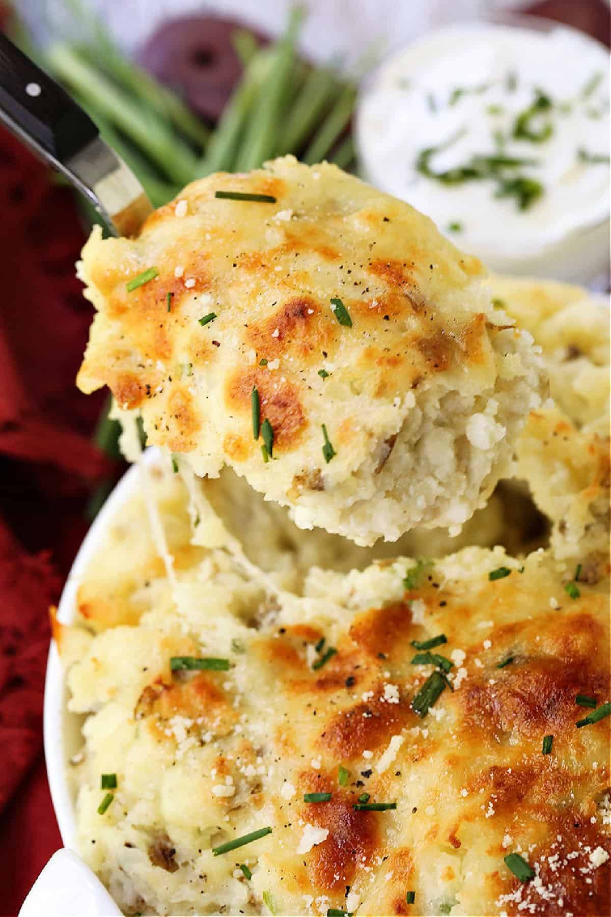 Potatoes Romanoff is a light and fluffy potato casserole with a unique cooking method! A make ahead side dish for parties and holidays! spoon serving a scoop of potato casserole