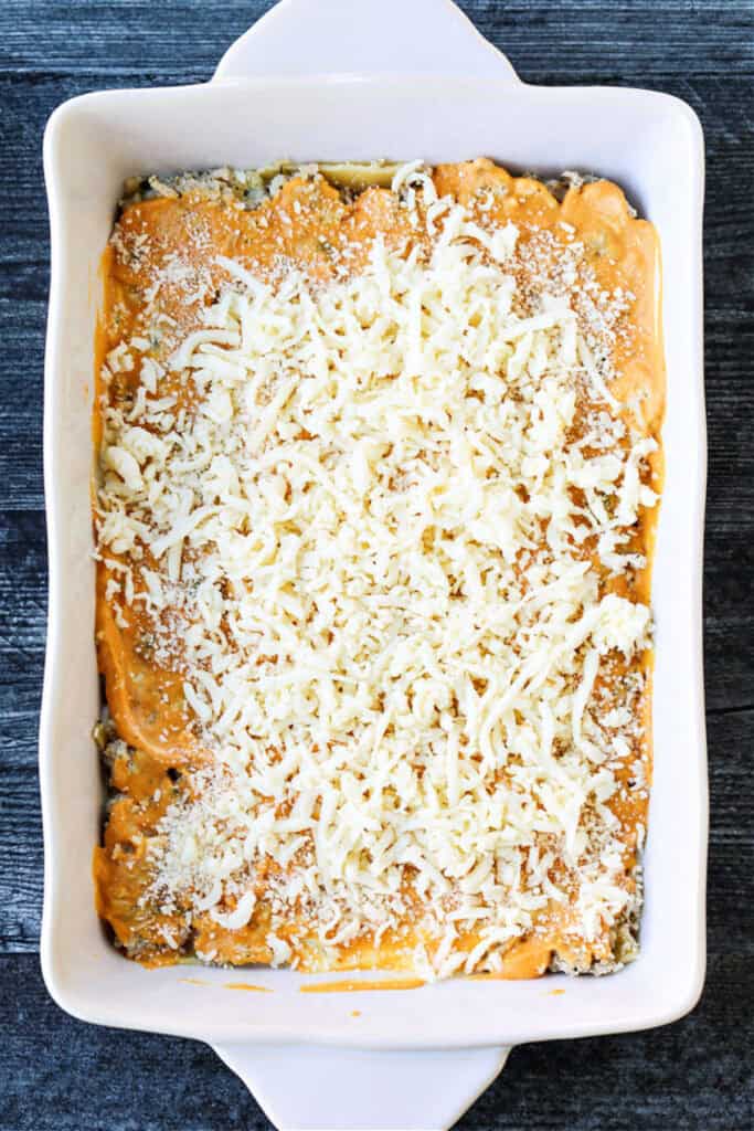 lasagna layered with shredded mozzarella cheese and pumpkin sauce