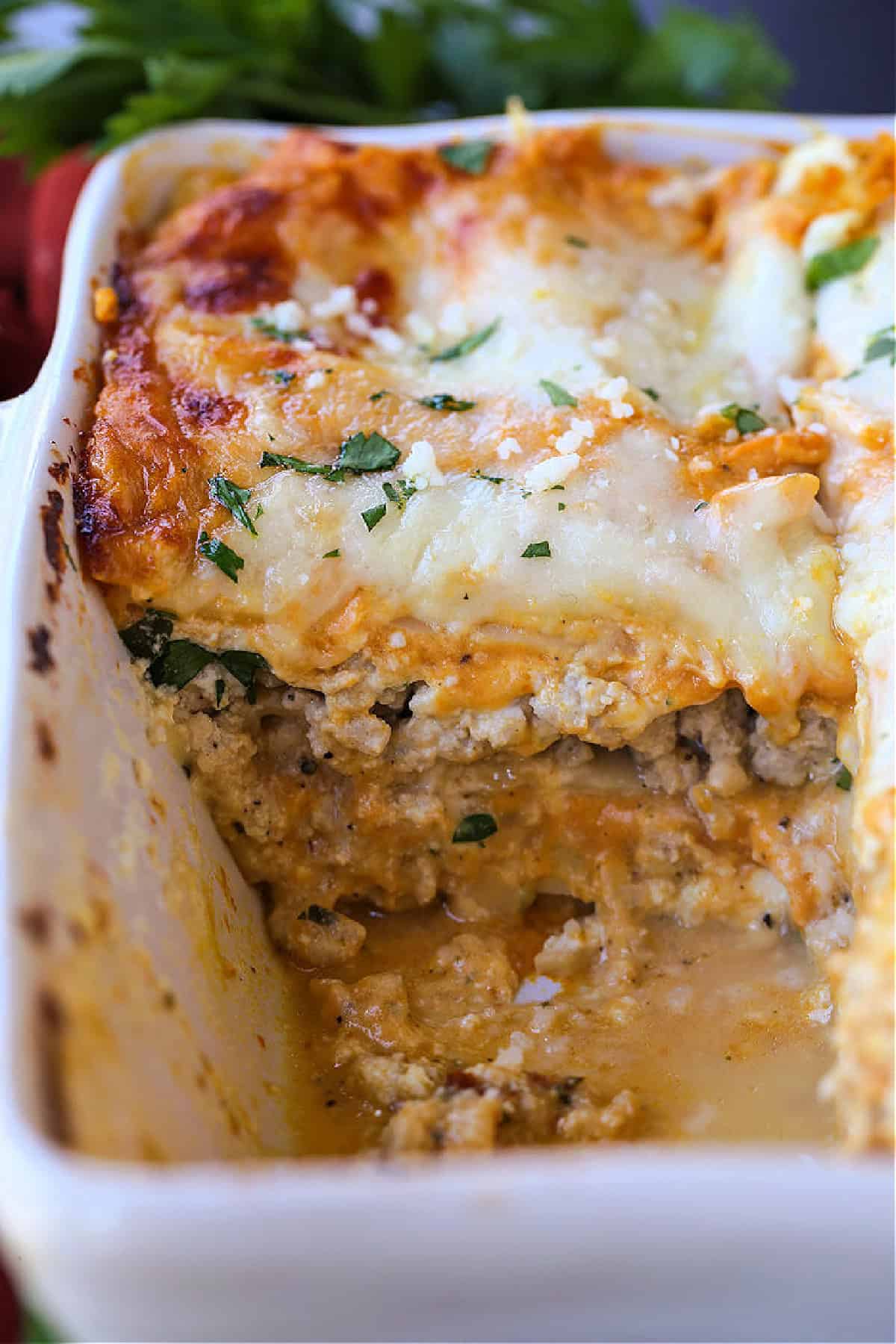 This Pumpkin Lasagna has the most delicious, creamy pumpkin Alfredo! All the cozy, fall vibes you're looking for in a lasagna recipe! slice taken out of lasagna dish