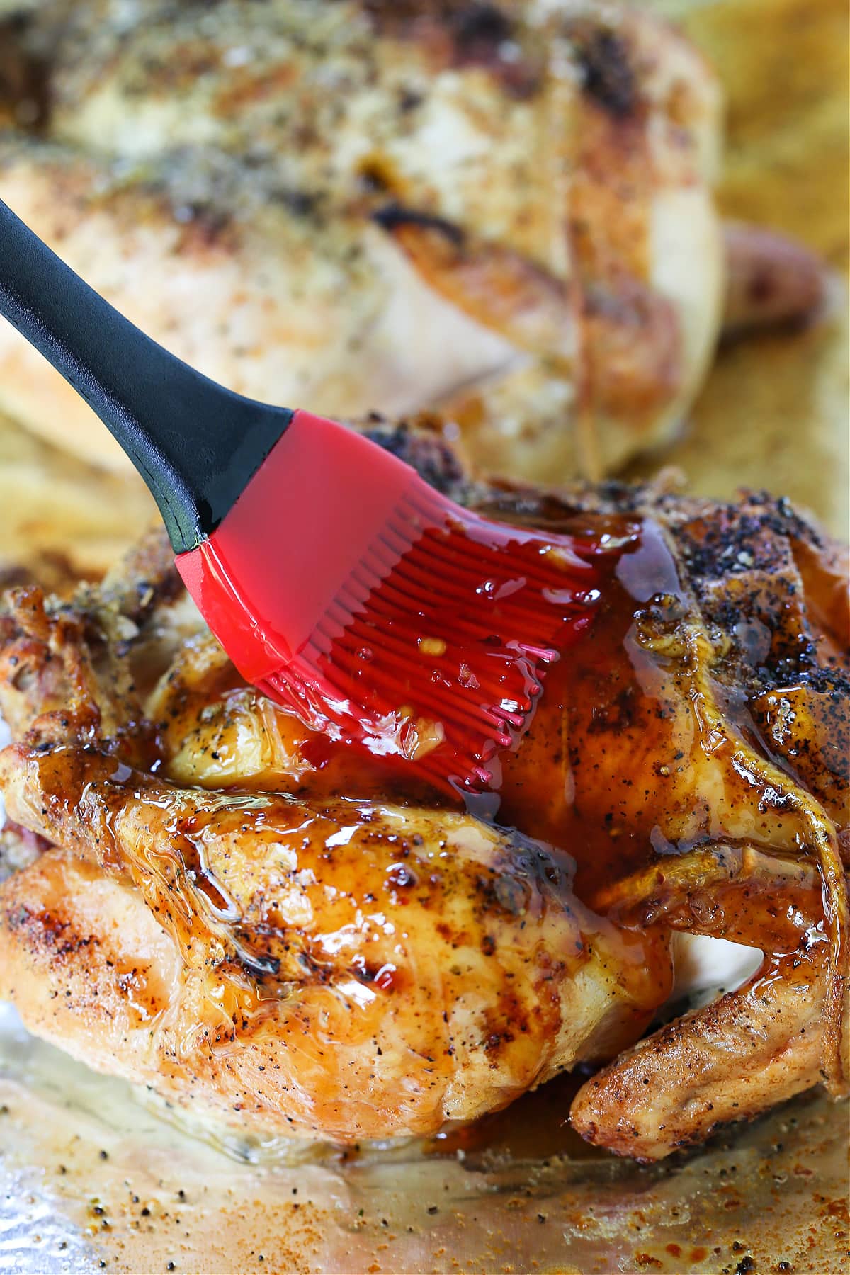 brushing glaze onto a roasted cornish hen