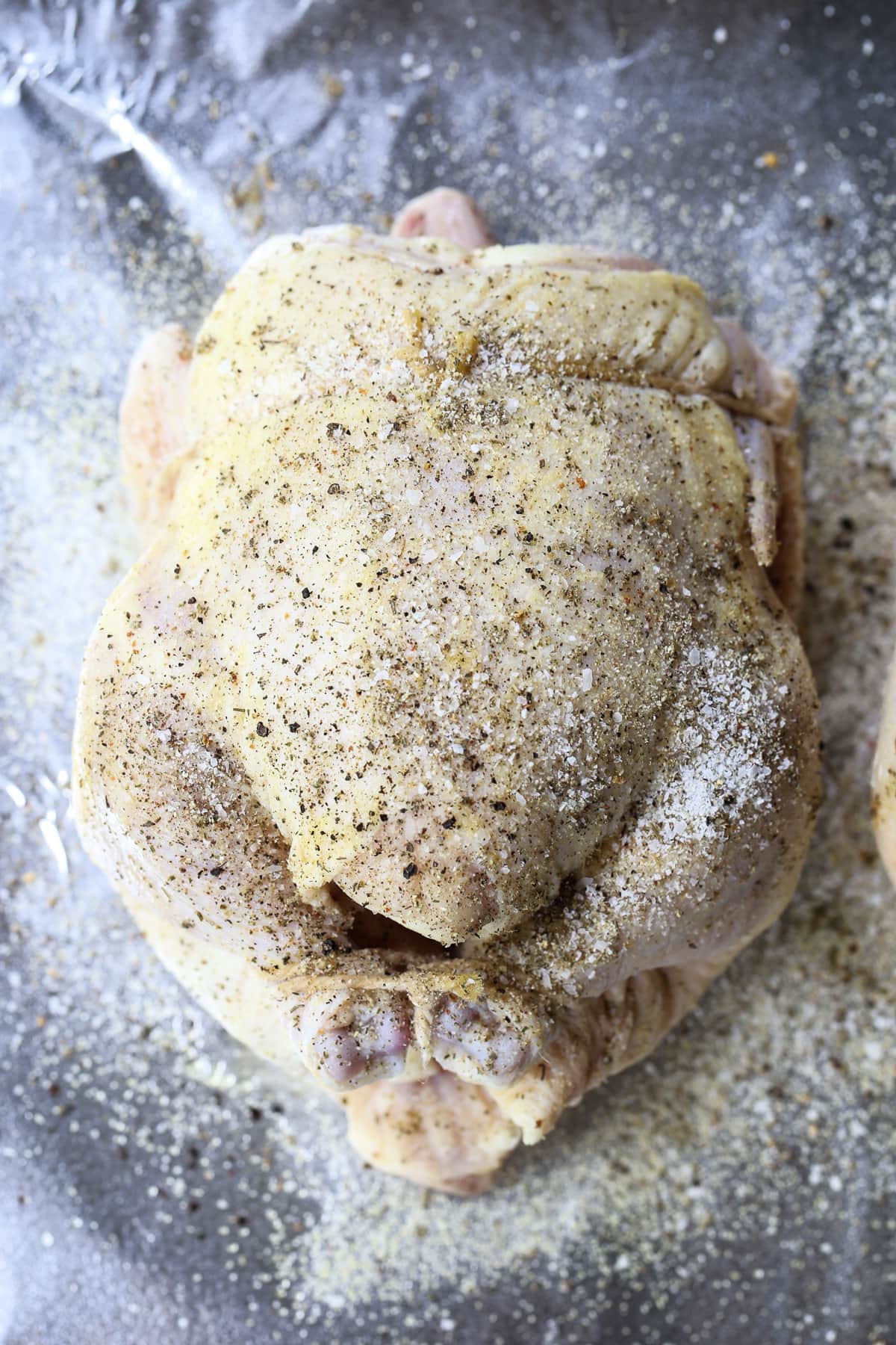 cornish hen seasoned and trussed on baking sheet