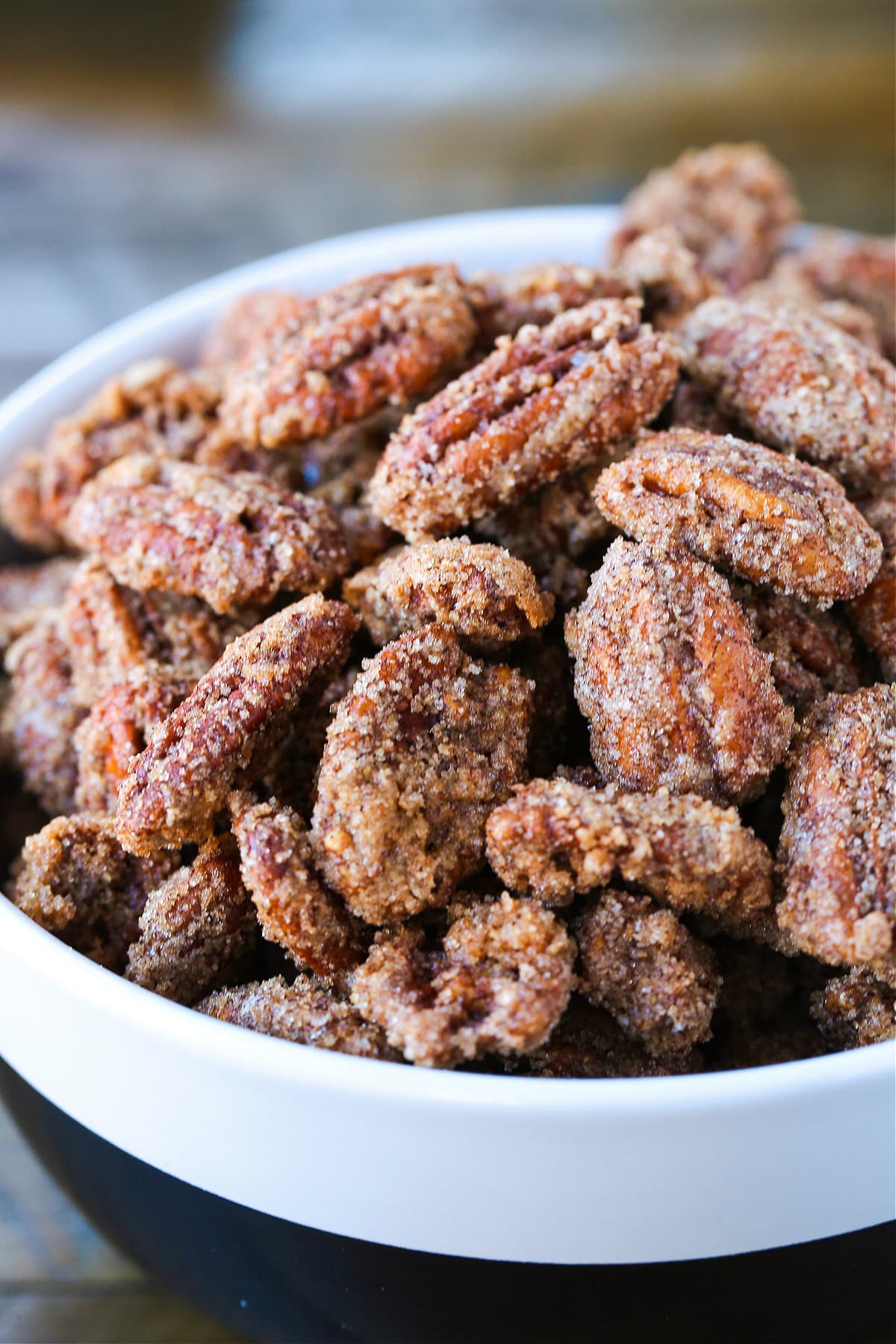 Our Candied Pecans Recipe is so addicting, you won't be able to stop eating them! A tasty snack recipe for parties, holidays and game days! candied pecans in a bowl close up