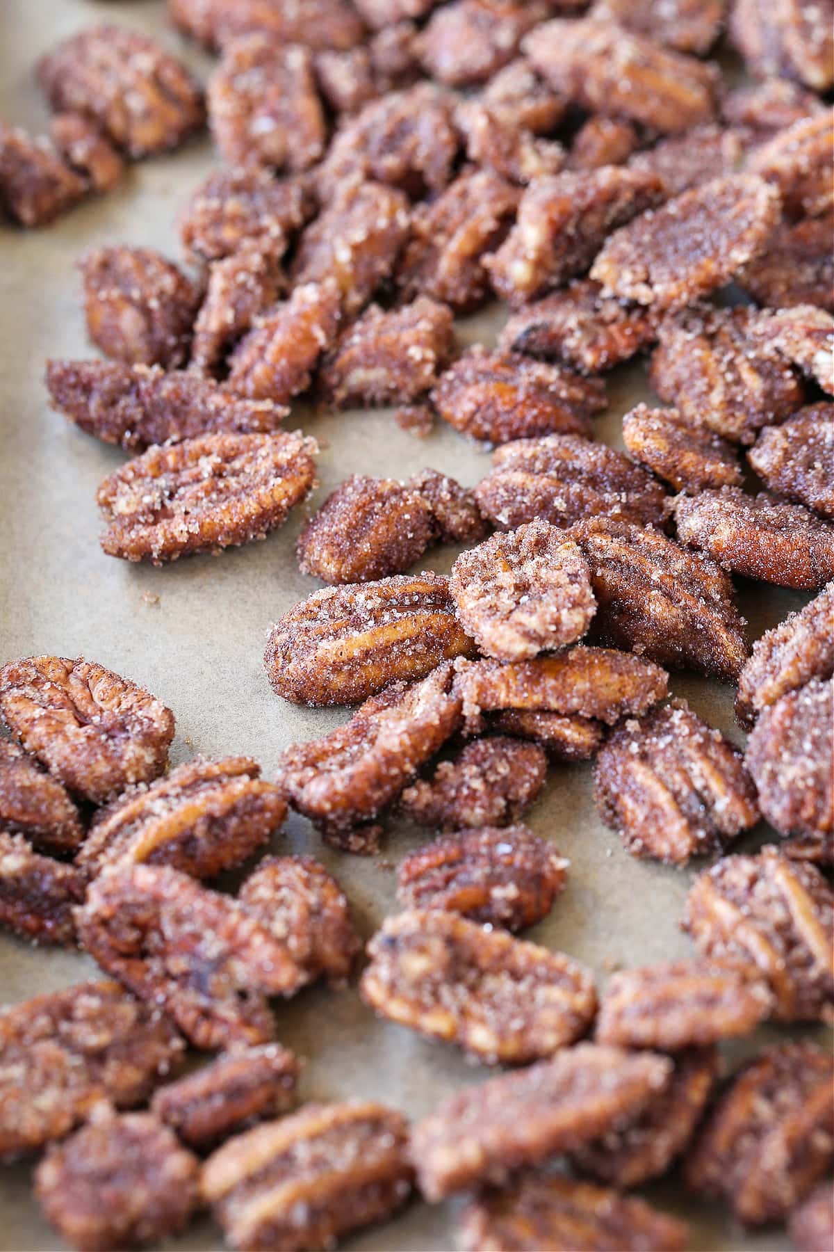 glazed pecans on baking sheet with parchment paper