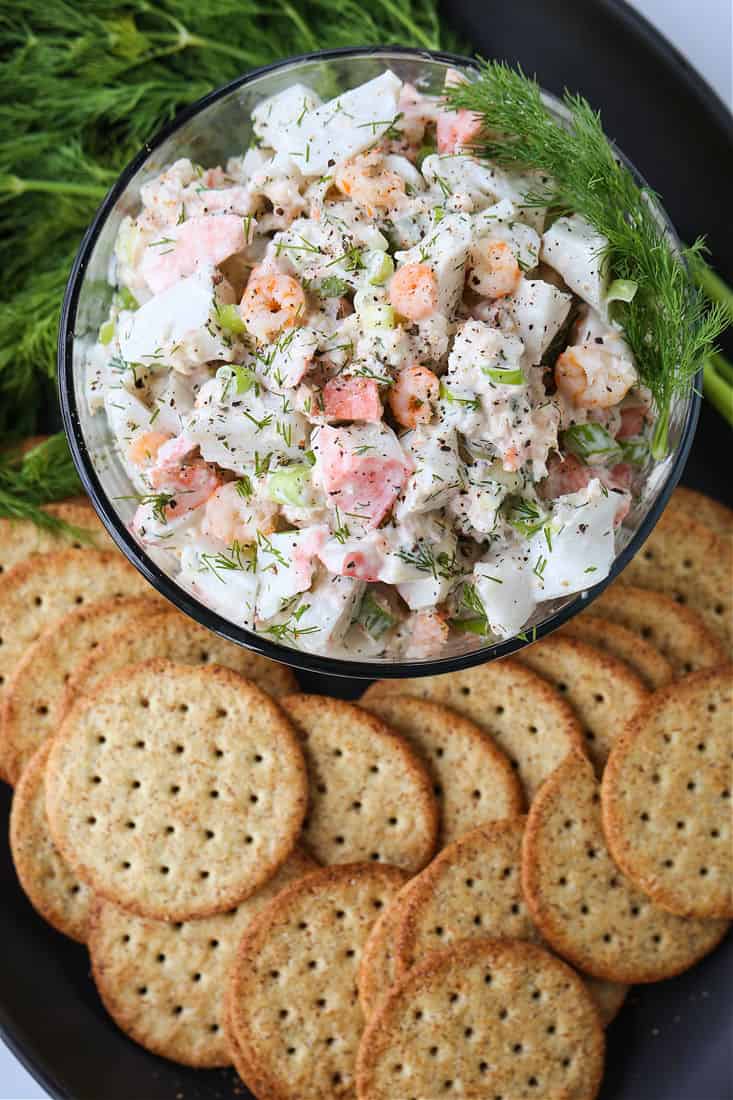 Cold seafood salad in a serving bowl with crackers