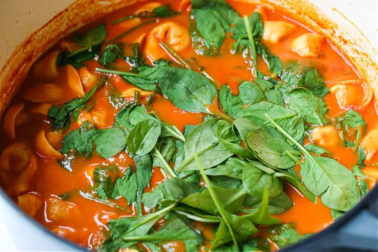 Fresh spinach in a pot to make tomato soup