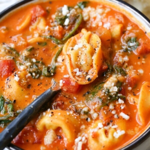 tomato tortellini soup with a spoon in the bowl