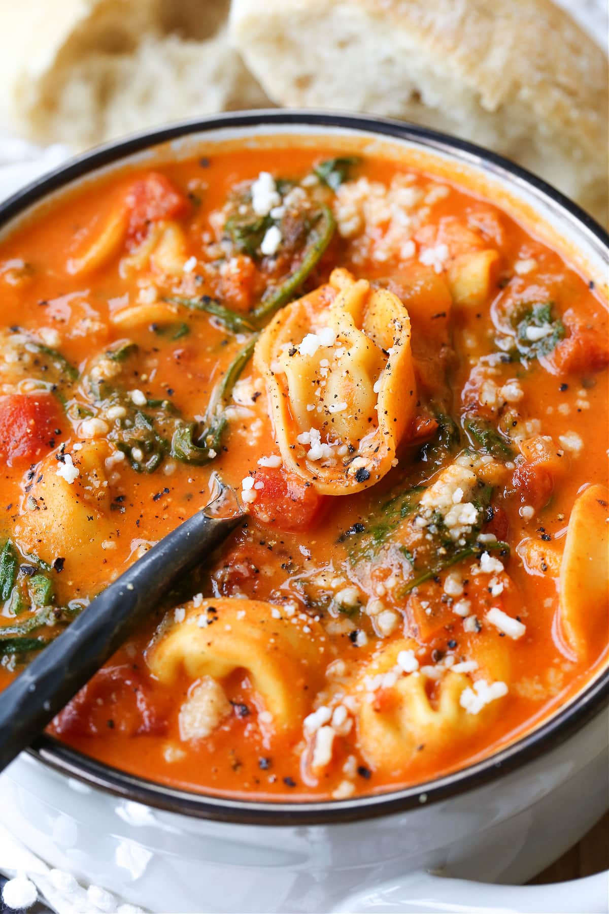 tomato tortellini soup with a spoon in the bowl